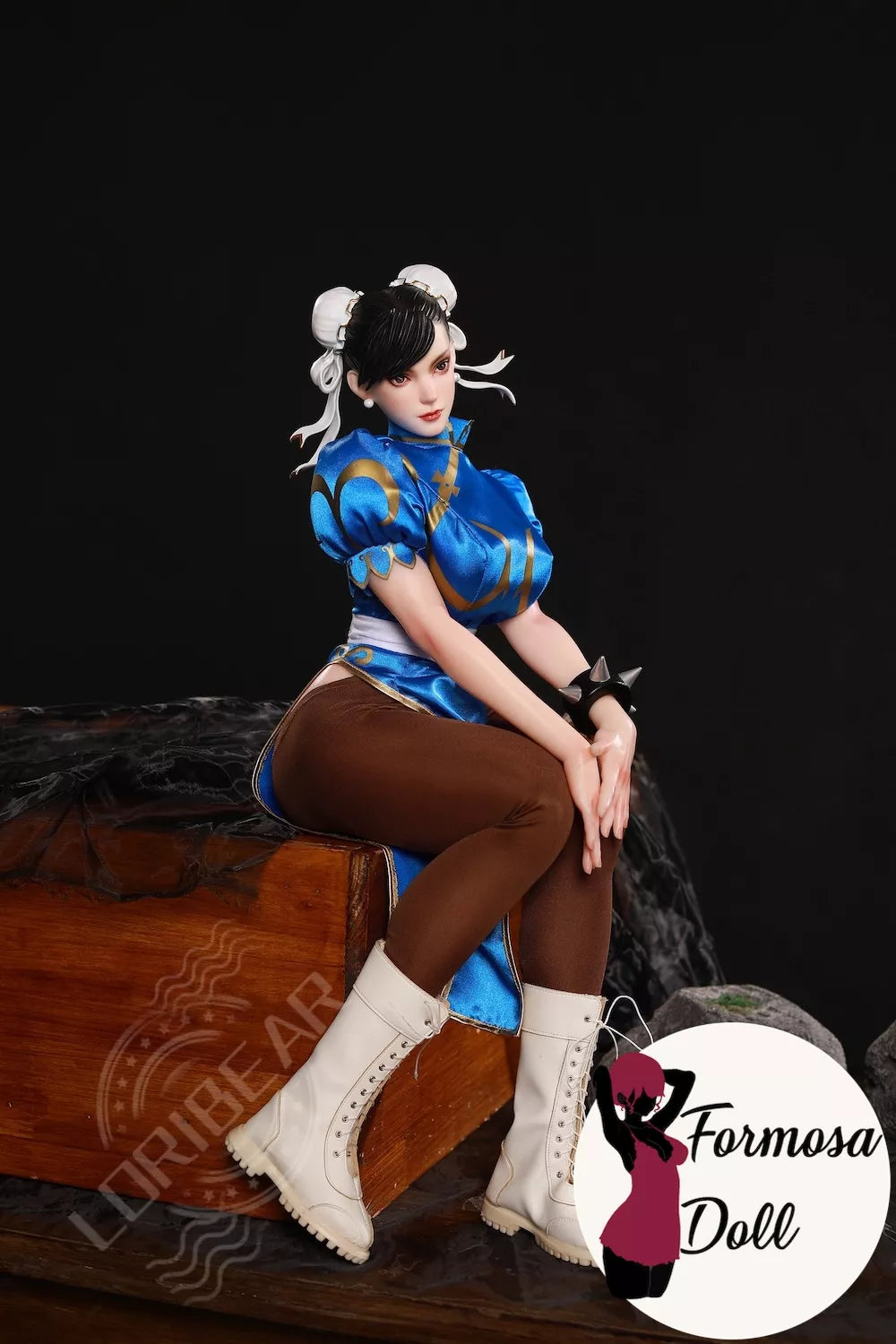 mini silicone figure in blue outfit with white boots sitting on a wooden surface, with 'Formosa Doll' branding.